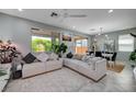 Inviting living room with a large sofa, modern ceiling fan, and ample natural light at 4160 Elegant Chateau St, Las Vegas, NV 89135
