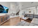 Spacious living room with hardwood floors, a large leather sofa, and a staircase leading to the second floor at 4326 Spooner Lake Cir, Las Vegas, NV 89147