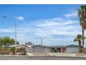 Inviting home with lush landscaping, desert front yard, freshly painted grey exterior, and an orange front door at 4404 Hillcrest Ave, Las Vegas, NV 89102