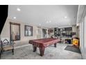 Large basement area with a pool table, exercise equipment, and tiled floors, perfect for entertainment at 601 Cragin Park Dr, Las Vegas, NV 89107
