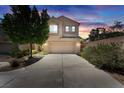 Charming two-story home with a two-car garage and front yard, illuminated by sunset at 6247 Sugartree Ave, Las Vegas, NV 89141