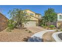 View of a two-story home with a brick driveway, manicured landscaping, and a two-car garage at 625 Loyalty Ct, Henderson, NV 89011