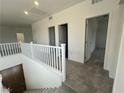 Bright upstairs hallway with gray carpet leading to several rooms at 64 Via Montoro, Henderson, NV 89011