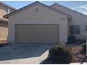 Attached two-car garage with neutral color and adjacent landscaped area at 6412 Starling Mesa St, North Las Vegas, NV 89086