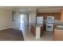 Open concept kitchen with light countertops, tile floors, and a center island at 6412 Starling Mesa St, North Las Vegas, NV 89086
