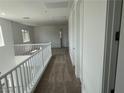 Upstairs hallway with neutral carpet, white walls and banister, and access to multiple rooms at 72 Via Montoro, Henderson, NV 89011