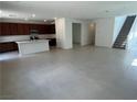 Expansive open-concept living area with tile flooring, a large kitchen island, and stairs leading to the upper level at 72 Via Montoro, Henderson, NV 89011