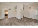 Bright living room featuring modern gray wood flooring and stylish light fixtures at 7417 Radville Dr, Las Vegas, NV 89129