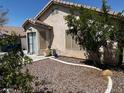 View of the private backyard featuring desert landscaping, a covered patio, and a convenient access door at 7850 Flagler St, Las Vegas, NV 89139