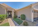 Inviting front entrance with a custom iron gate and meticulously landscaped pathway at 10013 Hunter Springs Dr, Las Vegas, NV 89134