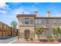 Attractive tan stucco condo building with well-maintained landscaping, multiple windows, and covered parking at 10180 Delray Beach Ave # 202, Las Vegas, NV 89129