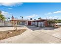 This single-story home has a red door, unique brick accents, and a well-maintained front yard at 1589 Silver Mesa Way, Las Vegas, NV 89169