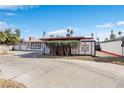 This single-story house features a well-maintained front yard, unique brick accents, and a red door at 1589 Silver Mesa Way, Las Vegas, NV 89169