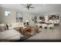 Open-concept living area featuring a plush sectional sofa, stylish decor, and seamless flow into the dining and kitchen at 2607 Regency Cove Ct # Lot 11, Las Vegas, NV 89121