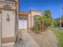 Close-up view of the home's entrance, featuring double doors, stone landscaping, and a well-manicured lawn at 2732 Dune Cove Rd, Las Vegas, NV 89117