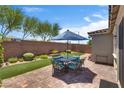 Outdoor patio area featuring pavers, artificial grass, and a dining set, creating a perfect space for entertaining at 2915 Moulton Crest Ave, Henderson, NV 89044