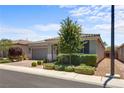 Inviting front exterior with lush landscaping, a paved driveway, and a charming desert-style xeriscaped yard at 2915 Moulton Crest Ave, Henderson, NV 89044