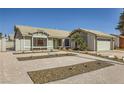 Single-story home featuring desert landscaping, a two-car garage, and a quaint front entryway at 335 Simon Bolivar Dr, Henderson, NV 89014