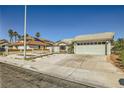 Single-story home with a two-car garage, desert landscaping, and a quaint front entryway at 335 Simon Bolivar Dr, Henderson, NV 89014