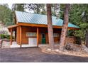 Log cabin with covered porch, woodpile, and green door for a cozy, rustic feel at 401 Alpine Way, Las Vegas, NV 89124