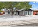 Charming single-story home with desert landscaping, a mature shade tree, and a two-car driveway at 404 Vassar Ln, Las Vegas, NV 89107