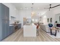 Spacious open-concept, featuring white walls, dining area, gourmet kitchen with large island and modern fireplace at 4176 Demoline Cir, Las Vegas, NV 89141