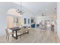 Inviting living space featuring modern chandelier over dining table and open flow to the living room and kitchen at 4176 Demoline Cir, Las Vegas, NV 89141