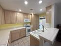 Bright kitchen with modern appliances, tiled countertops and ample cabinet space at 5424 Comchec Way # 101, Las Vegas, NV 89108