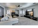 Spacious living room with a fireplace, a ceiling fan, neutral walls, and ample natural light at 6052 Puesta Del Sol St, North Las Vegas, NV 89081