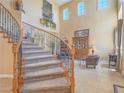 Elegant foyer featuring a curved staircase with iron railings, soaring ceilings, and tile flooring at 8106 Eagle Clan Ct, Las Vegas, NV 89131