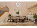 Dining room with hardwood floors, modern chandelier, and seating for six at 8220 Chimney Bluffs St, North Las Vegas, NV 89085