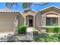 Beautiful home featuring a well-manicured lawn, front shrubs, and a covered entryway at 9220 Evergreen Canyon Dr, Las Vegas, NV 89134