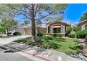 Inviting single-story home showcasing a well-manicured lawn, desert landscaping, and a tile roof at 9220 Evergreen Canyon Dr, Las Vegas, NV 89134