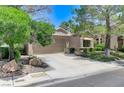 Welcoming home with desert landscaping, mature trees, and a two-car garage at 9220 Evergreen Canyon Dr, Las Vegas, NV 89134