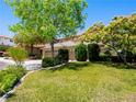 Well-maintained front yard with lush green grass, mature trees, and desert landscaping at 10612 Gum Tree Ct, Las Vegas, NV 89144