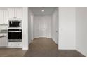 Modern kitchen with stainless steel appliances, ample white cabinets, and tiled flooring at 1398 Pin Cushion Rdg, Mesquite, NV 89034
