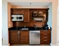 Kitchenette area with dark wood cabinetry, stainless steel appliances, sink, and a coffee maker at 145 E Harmon Ave # 2409, Las Vegas, NV 89109