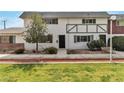 Charming two-story home with a well-manicured lawn and mature landscaping at 163 Greenbriar Townhouse Way, Las Vegas, NV 89121
