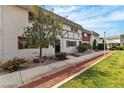 Charming two-story home with a well-manicured lawn and mature landscaping at 163 Greenbriar Townhouse Way, Las Vegas, NV 89121