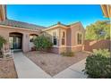 Charming home exterior featuring a tiled roof, decorative windows, and meticulously manicured desert landscaping at 2039 Colvin Run Dr, Henderson, NV 89052