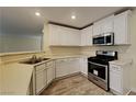 Well-lit kitchen with stainless steel appliances, white cabinets, and modern countertops at 209 Copper Pine Ave, North Las Vegas, NV 89031