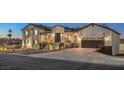 This beautiful two-story home features a spacious driveway and inviting entryway, perfect for modern living at 210 E Longacres Dr, Henderson, NV 89015