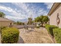 Charming courtyard featuring decorative metal lawn furniture, mature shade trees, and desert landscaping at 3071 Lake Barkley Rd, Henderson, NV 89052