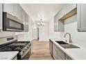 Stylish kitchen with grey cabinets, stainless steel appliances, and a view into the dining area at 3318 N Decatur Blvd # 1107, Las Vegas, NV 89130