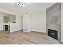 Stylish living room with fireplace, contemporary lighting, and wood-look flooring open to kitchen at 3318 N Decatur Blvd # 1107, Las Vegas, NV 89130