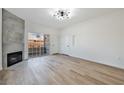 Bright living room with wood-look floors, contemporary lighting, fireplace, and sliding door to balcony at 3318 N Decatur Blvd # 1107, Las Vegas, NV 89130