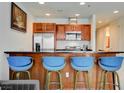 Stylish kitchen features stainless steel appliances, brown cabinets and a breakfast bar with four blue chairs at 4525 Dean Martin Dr # 901, Las Vegas, NV 89103