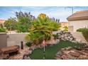 Lush backyard putting green with rock features, mature landscaping, and ample space for outdoor enjoyment at 499 Eagle Vista Dr, Henderson, NV 89012