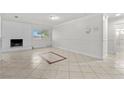 Bright living room with large tile flooring, freshly painted walls and a brick fireplace at 5101 Churchill Ave, Las Vegas, NV 89107