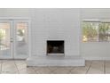 Bright living room with a painted brick fireplace and tile flooring at 5101 Churchill Ave, Las Vegas, NV 89107